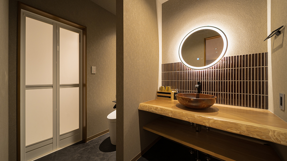 円形の鏡と照明が素敵な洗面スペース