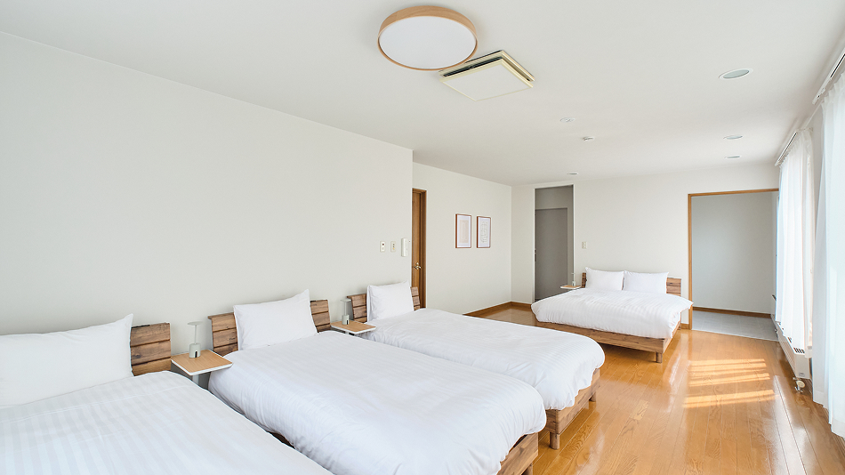 寝室は全部で4部屋！こちらはシングルベッドが3台とダブルベッドが1台のお部屋です