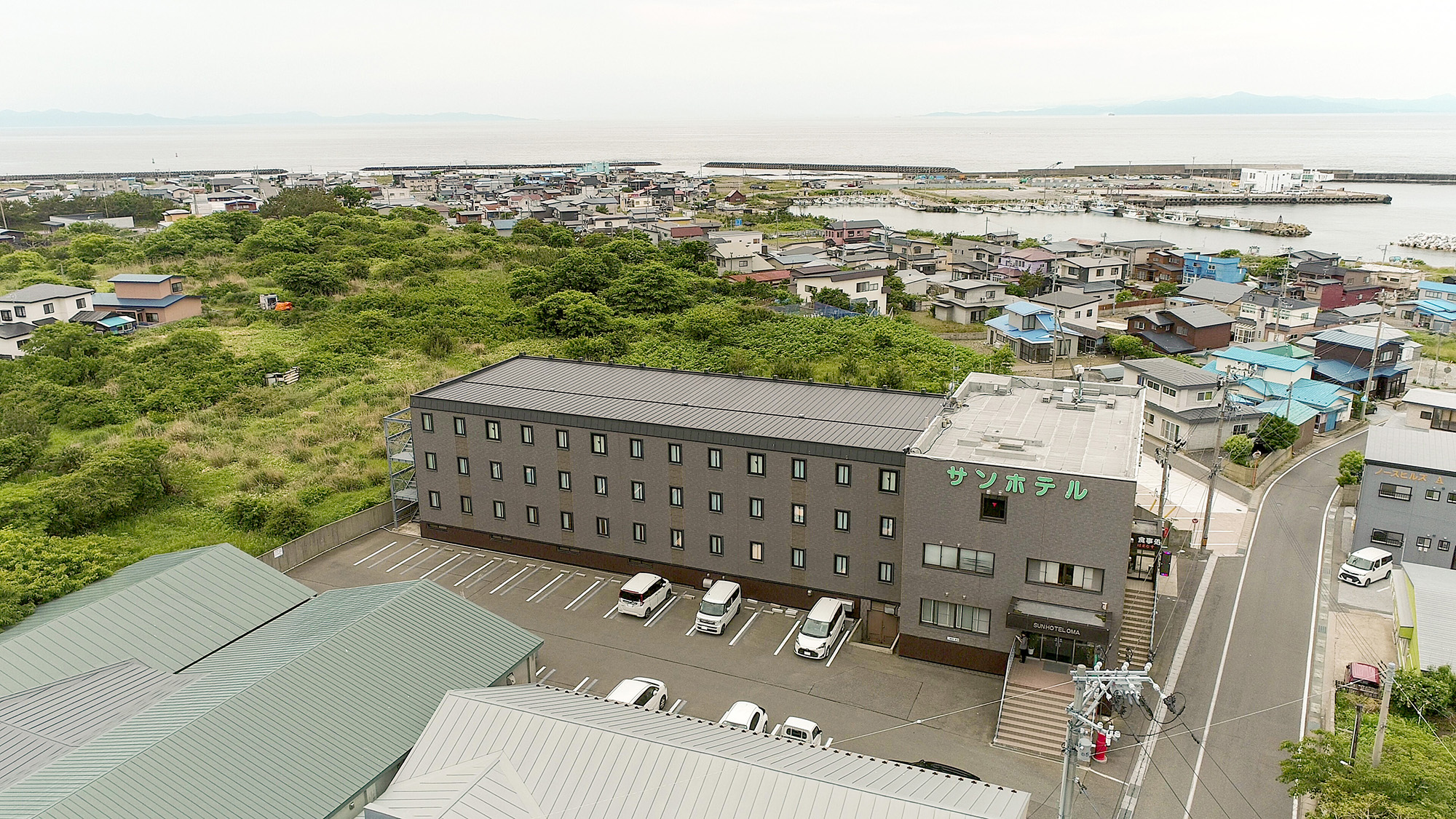 #外観　上空から見た当ホテルと、その先に広がる美しい海。