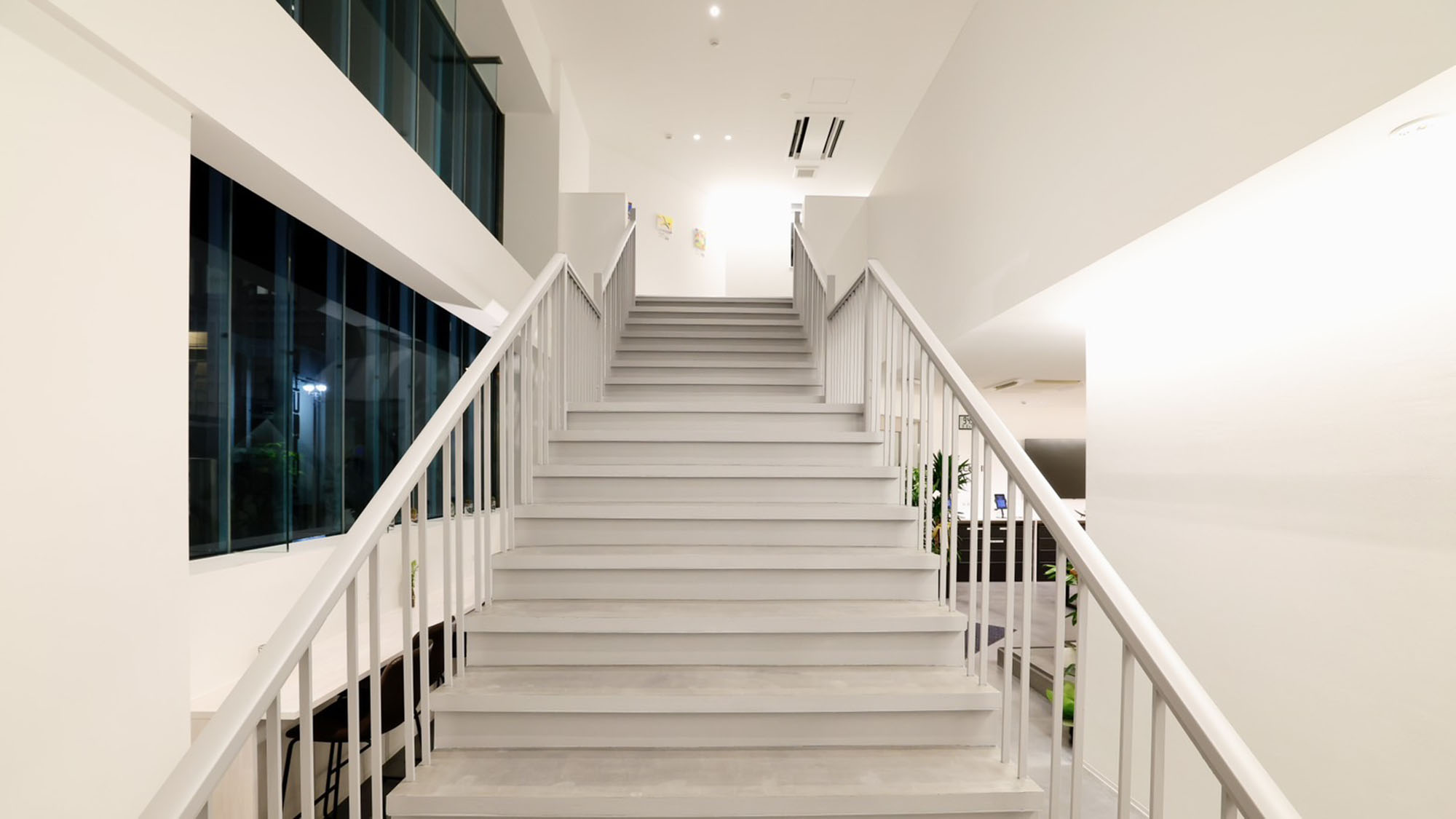 ・【館内】2階へ続く階段の先には、障がい者アーティストの作品を飾る踊り場がございます