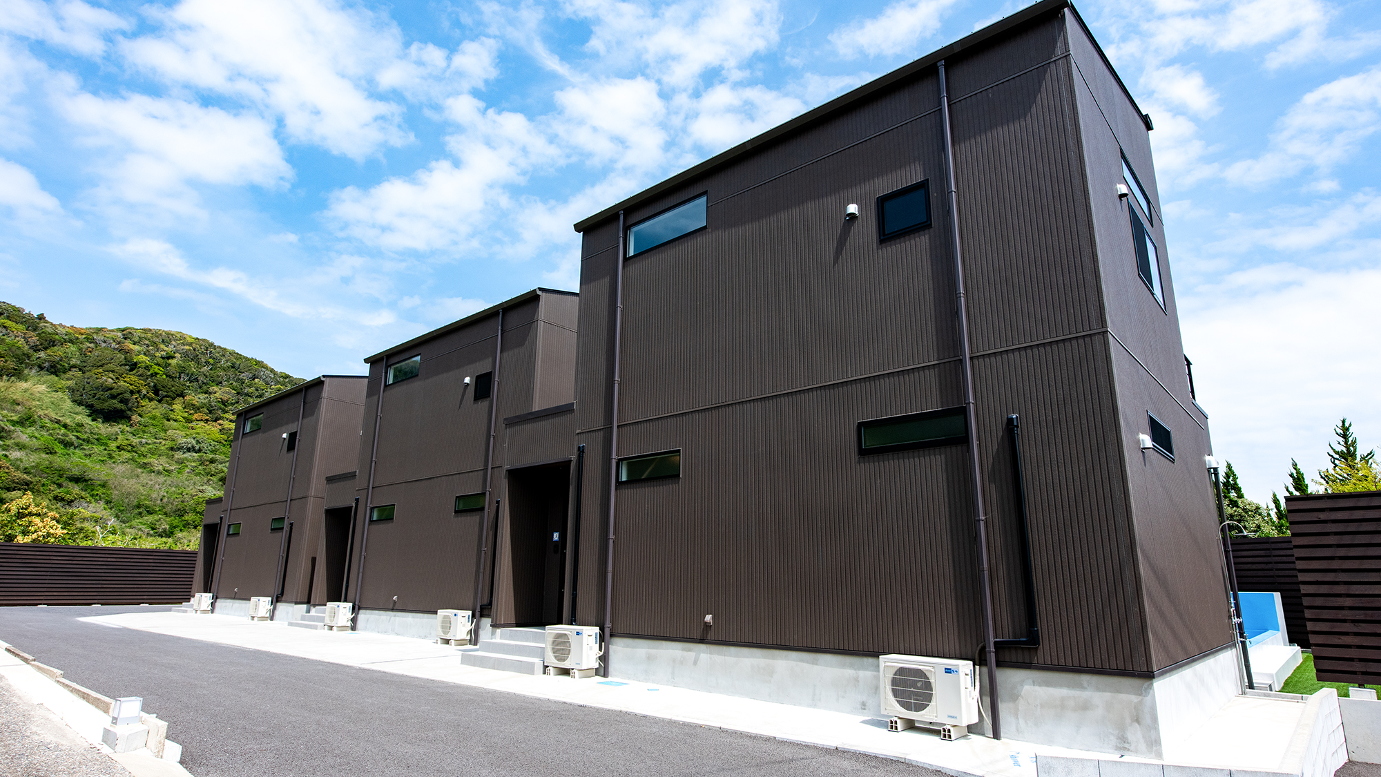 *【外観（入口）】自然に囲まれた静かな環境に佇むモダンな建物。