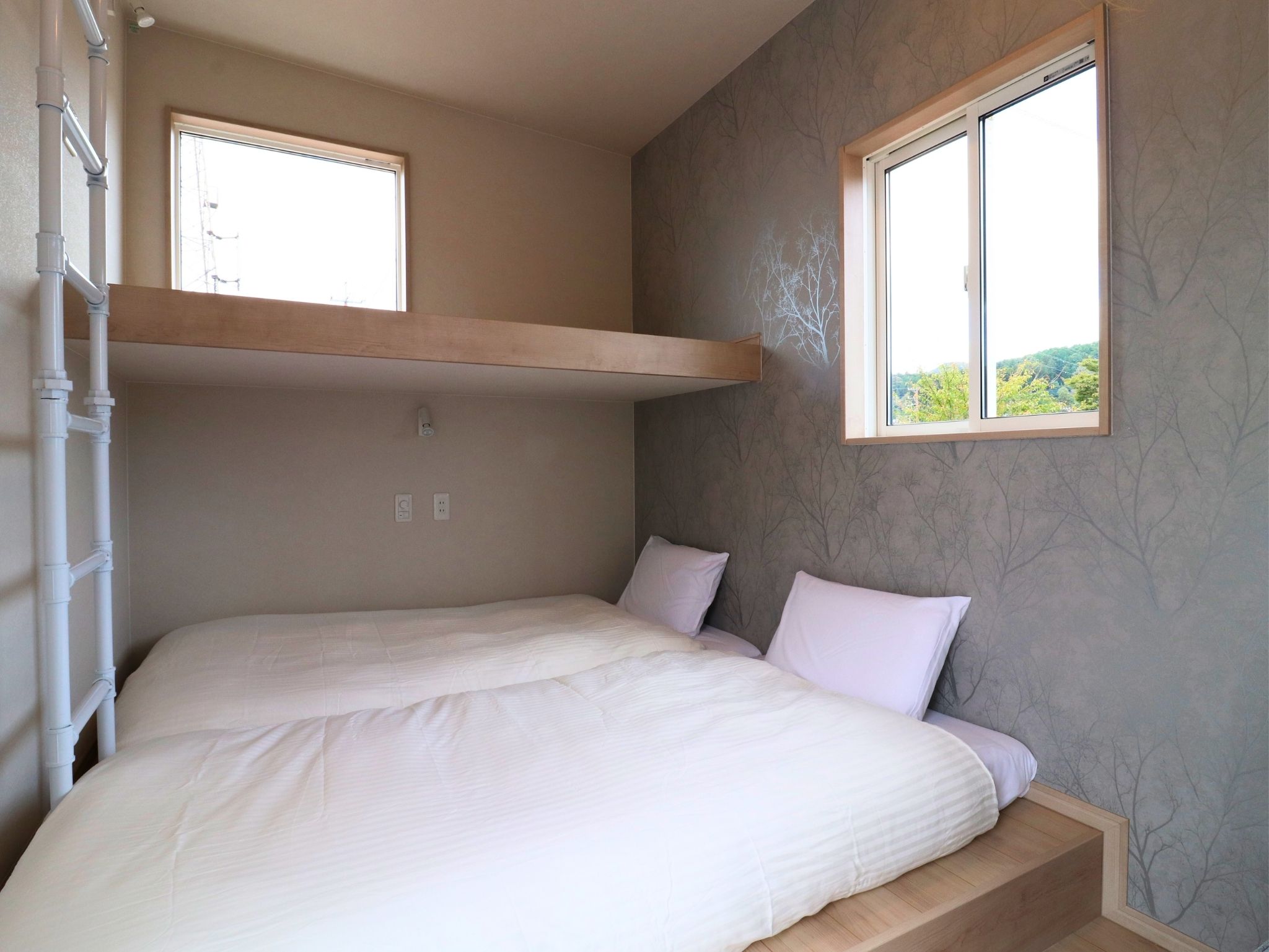 【シングル3台、ソファベッド1台】ウッドテイストで統一した落ち着きのあるスタンダードタイプ。リビングと寝室をゆるやかに分けた間取りで、くつろぎとプライバシーの両立を実現しました。3棟あるなかでも一番広さを感じる洋室タイプのお部屋です。