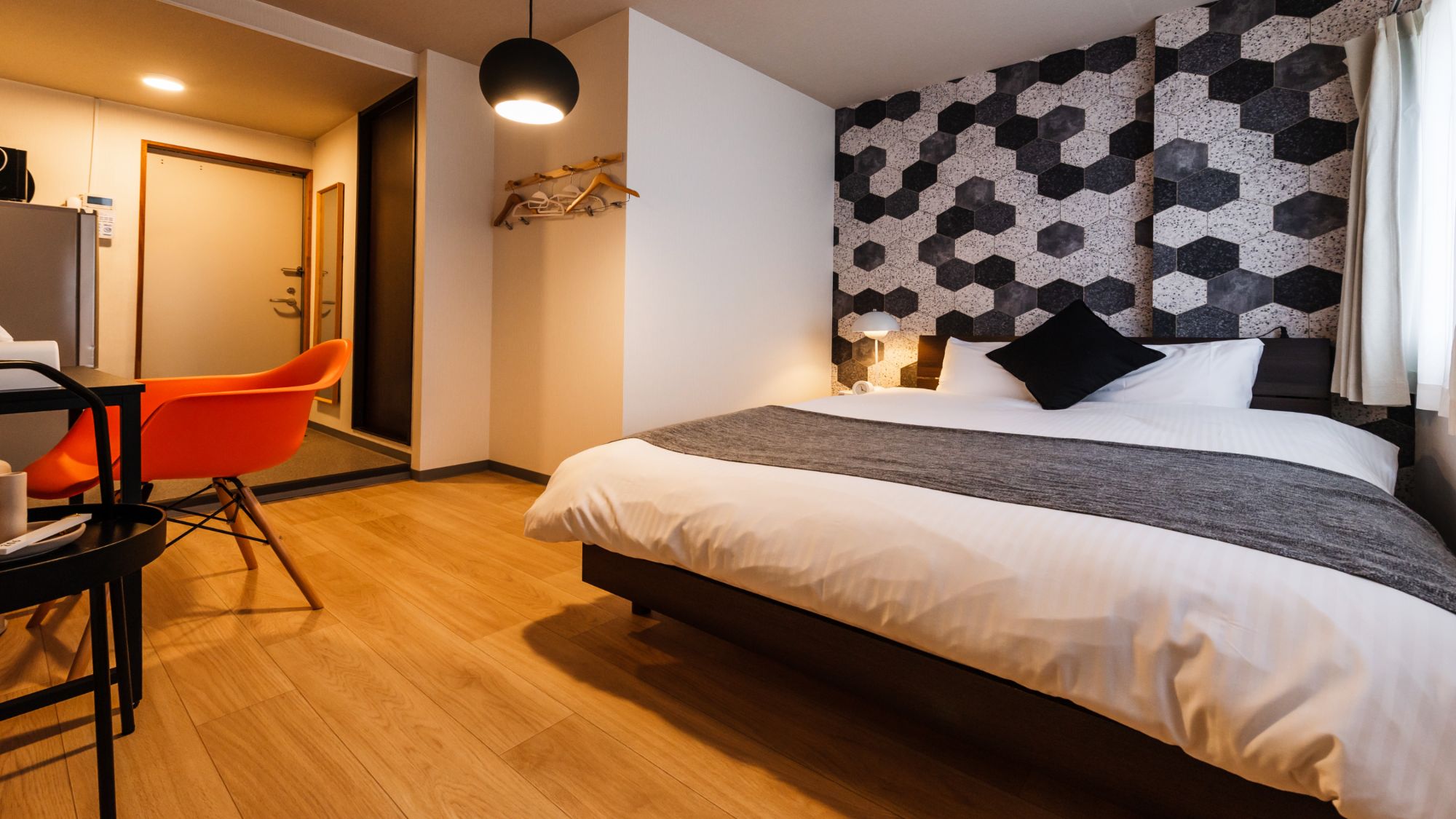 【ダブルルーム（シャワー・トイレ付）2－3階】幾何学模様の壁紙が目を引くモダンな一室。