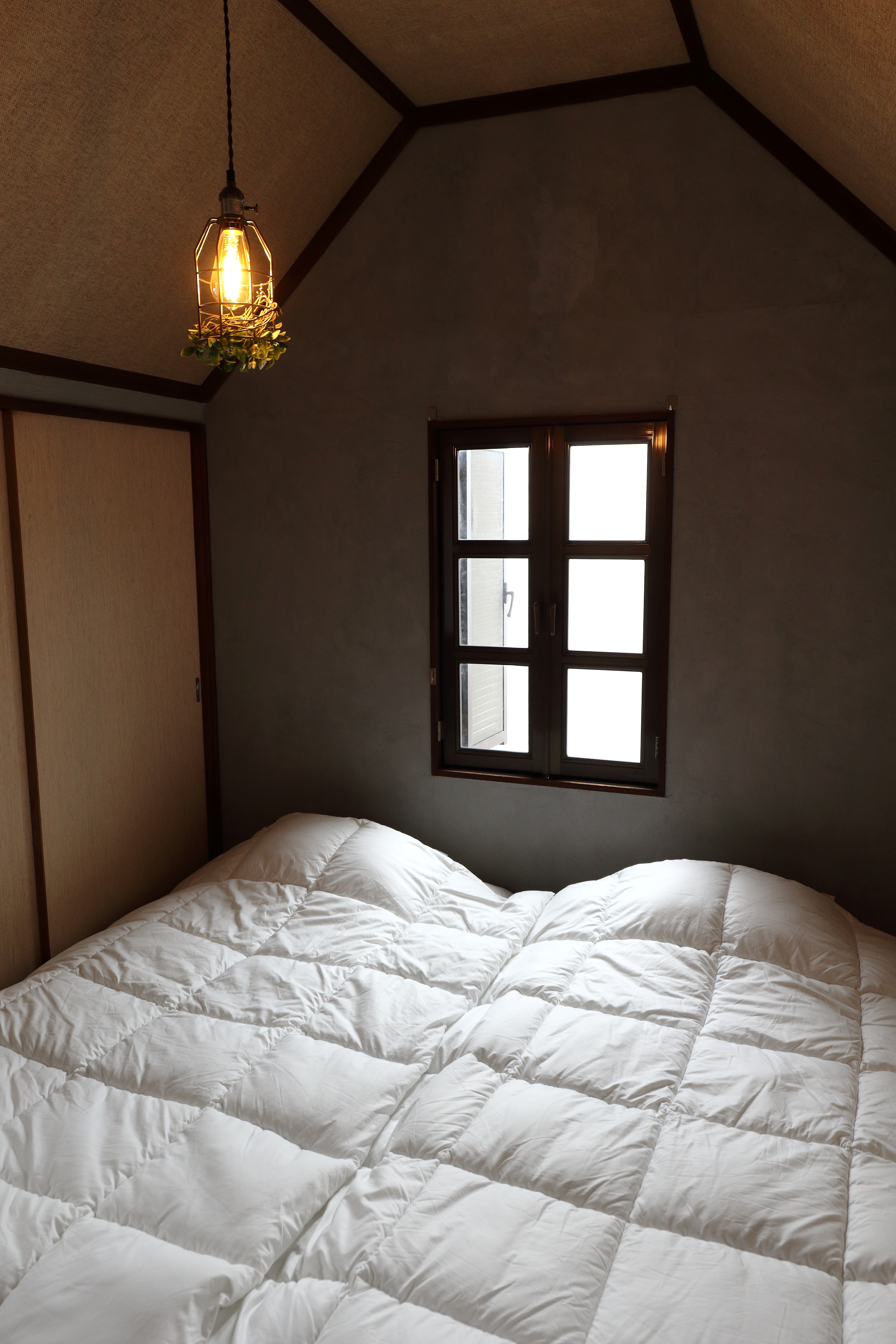 ３Ｆメインの寝室です。 狭さが心地よい空間でぐっすりとお休みいただけます。 唯一洋窓となっている部屋で、さりげない「洋」のテイストをお楽しみください。