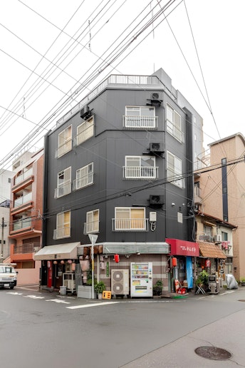 写真の黒い建物の２階から４階をまとめてお一組限定で貸し出しております。１階はお好み焼き屋さんです。