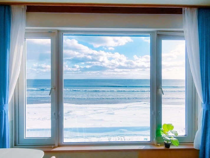 冬の白い雪で覆われた海岸