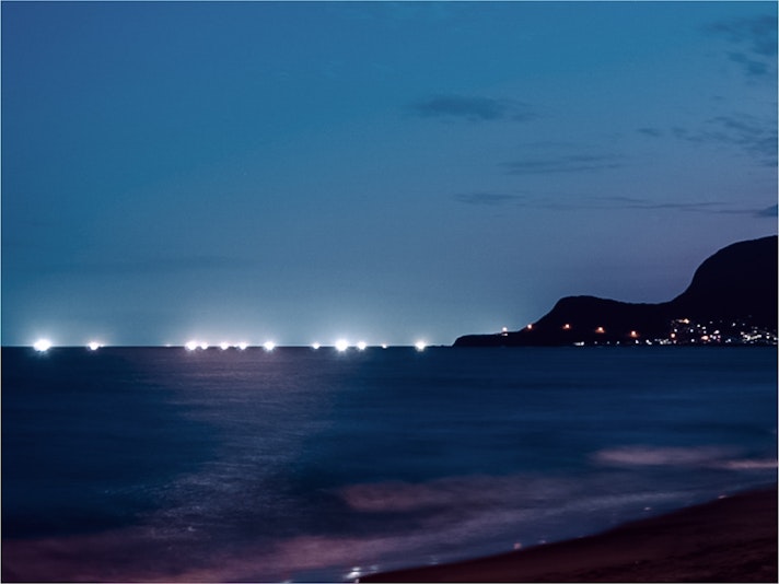 夏と秋の夜、イカ釣り船の漁火が輝く