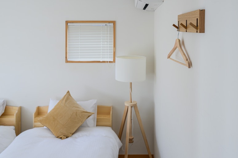 ベッドサイドに照明とハンガーを備えた使いやすい寝室です。