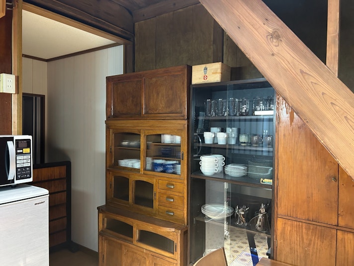 昭和レトロな木製の食器棚には、旅の時間を彩る器やグラスがずらりと並んでいます。朝のコーヒーにちょうど
