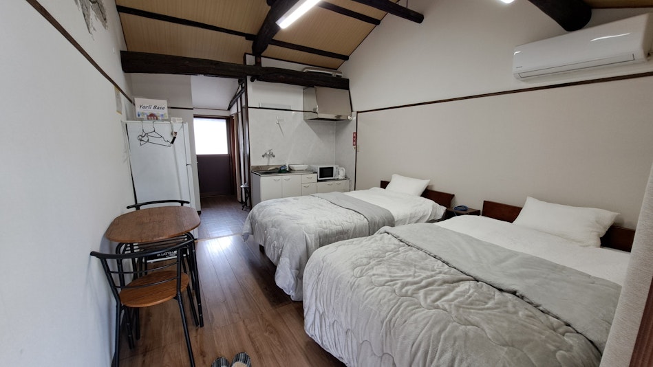 ベッド、シャワールーム、ミニキッチン、洗面台、トイレがあります。