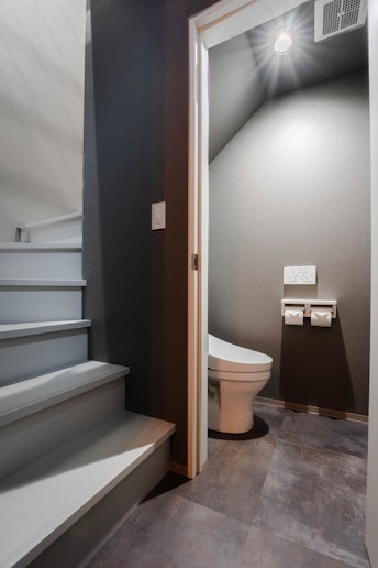 キッチンから続く階段で2階へ。階段下にはトイレスペースがございます。