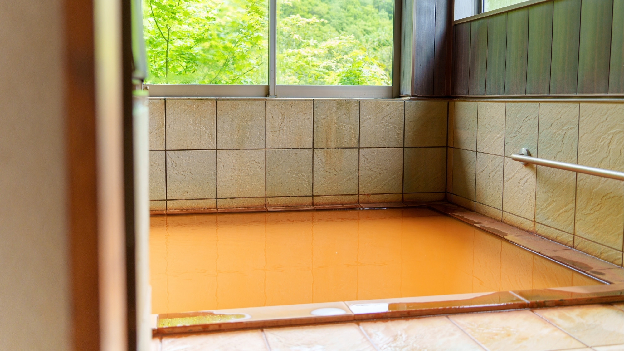 木々に囲まれた秘湯風呂「岳」濃厚な赤褐色の秘湯がたっぷり注がれる湯舟。