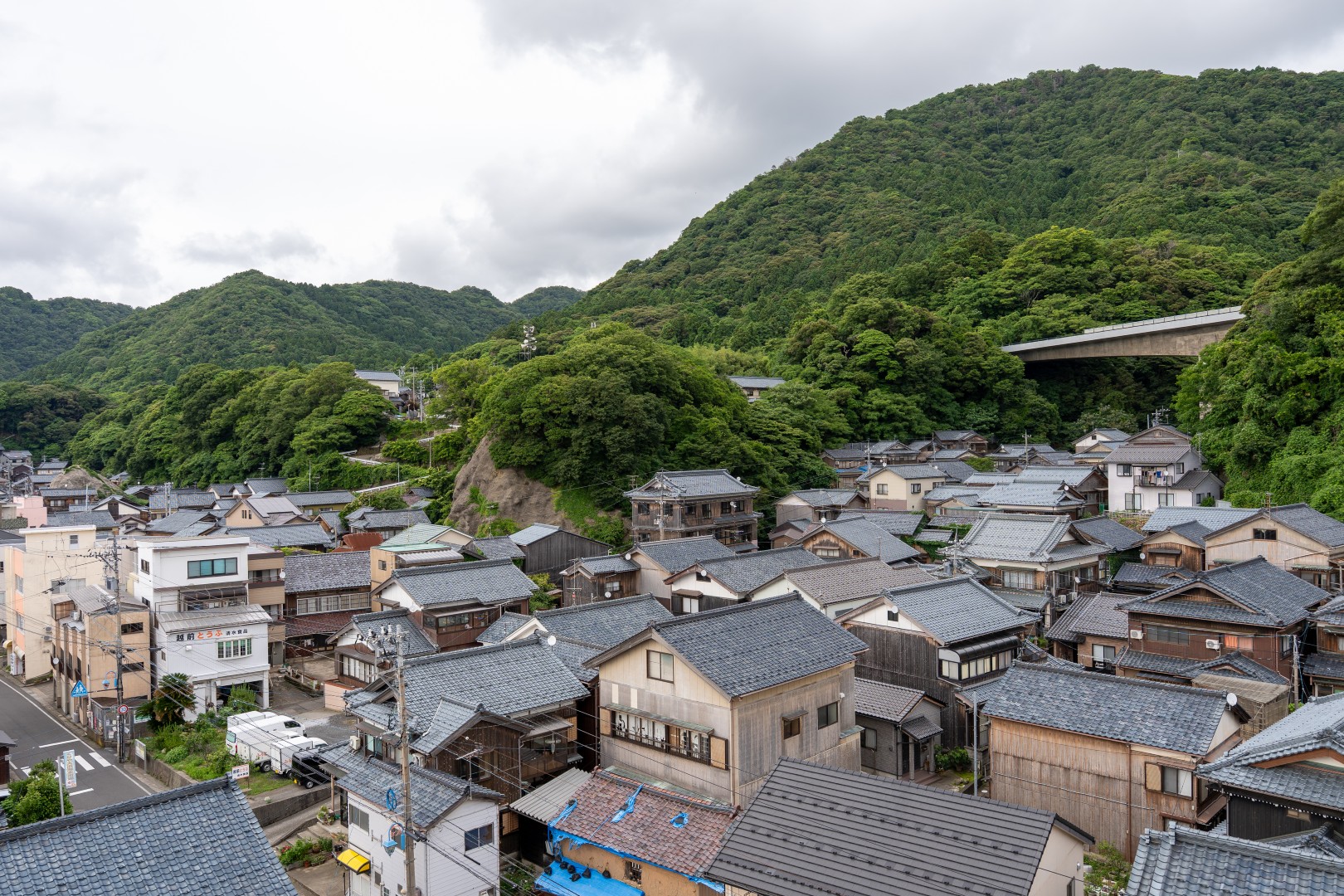 歴史ある漁師町の瓦屋根と豊かな山並み。