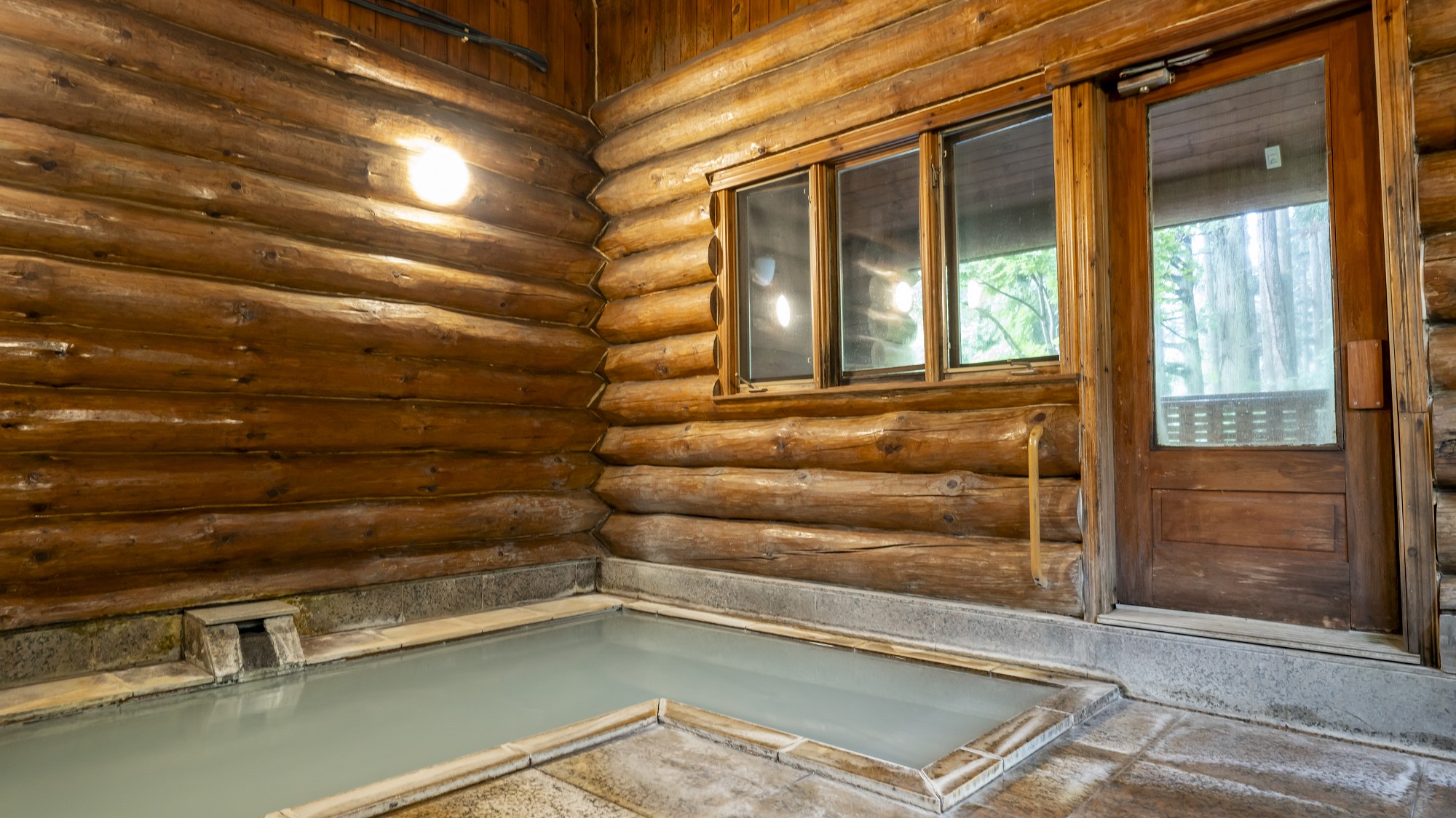 【ログハウス大浴場】日によって乳白色、緑白色等に変化し、たちこめる硫黄の香りが温泉らしい温泉