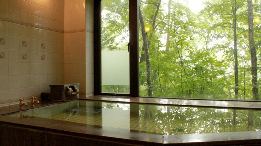 *大浴場：男湯／グリーンシーズンには、窓の外の緑の眺めながらご入浴いただけます。
