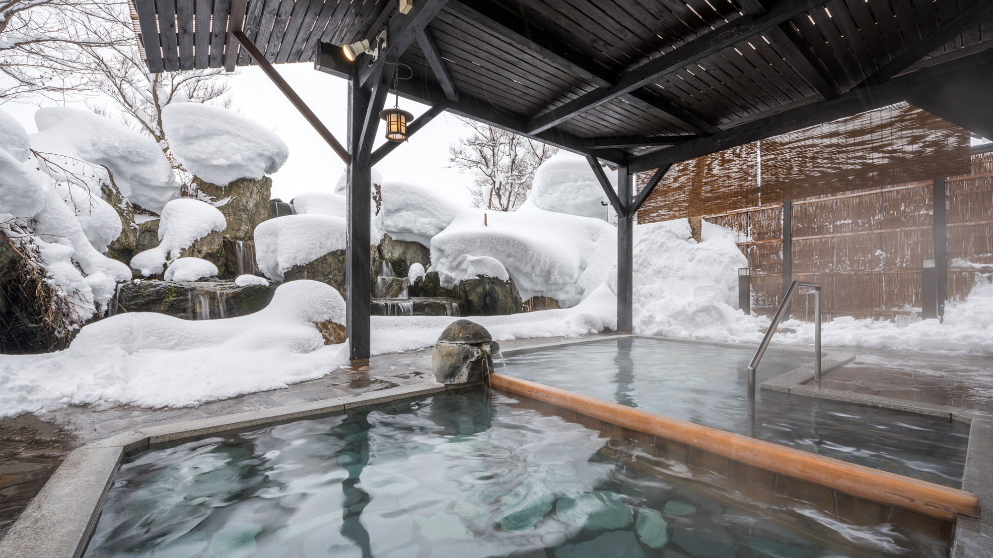 雪景色・源泉100％完全かけ流し！ラジウムイオン豊富な美人の湯「せせらぎ」滝の流れる露天風呂です。