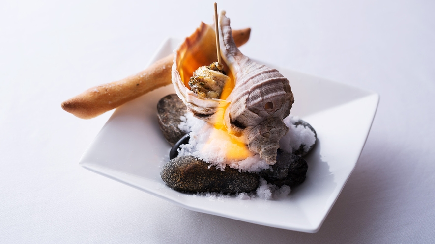 【夕食一例】日高の名産・つぶ貝をフレンチには珍しいアヒージョでご提供。（その時期の旬の魚介を使用）