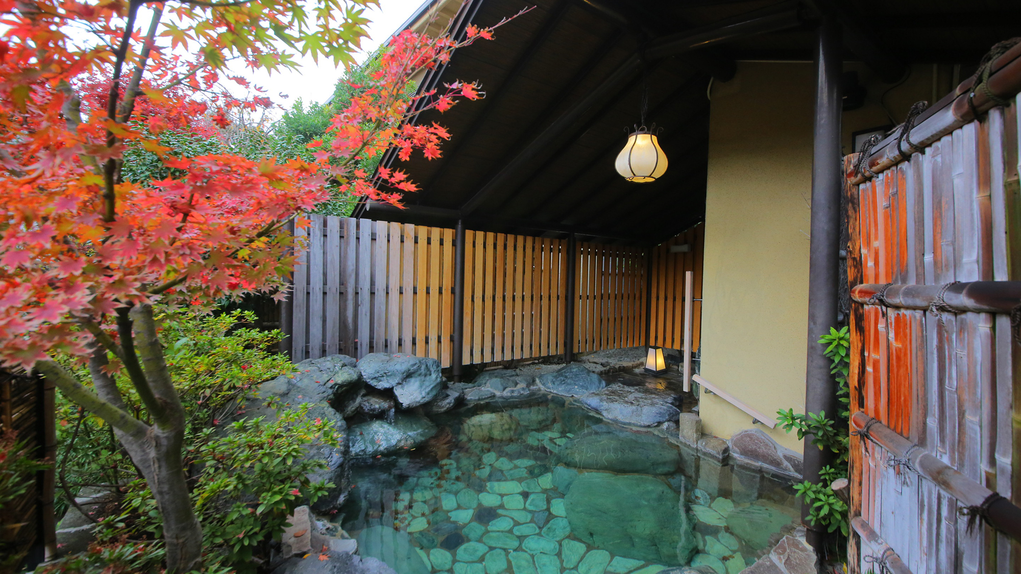 赤く染まる葉が揺れる露天風呂