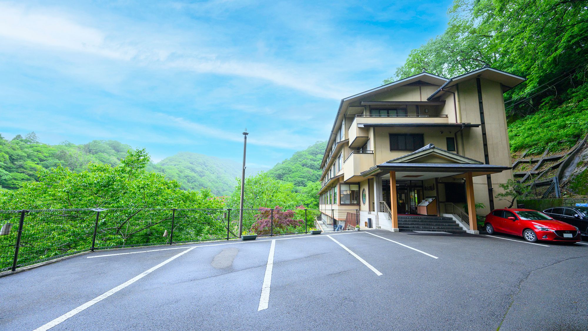 新緑の帝釈峡に佇む錦彩館の正面玄関です。駐車場を完備しておりますのでお車でも安心です。