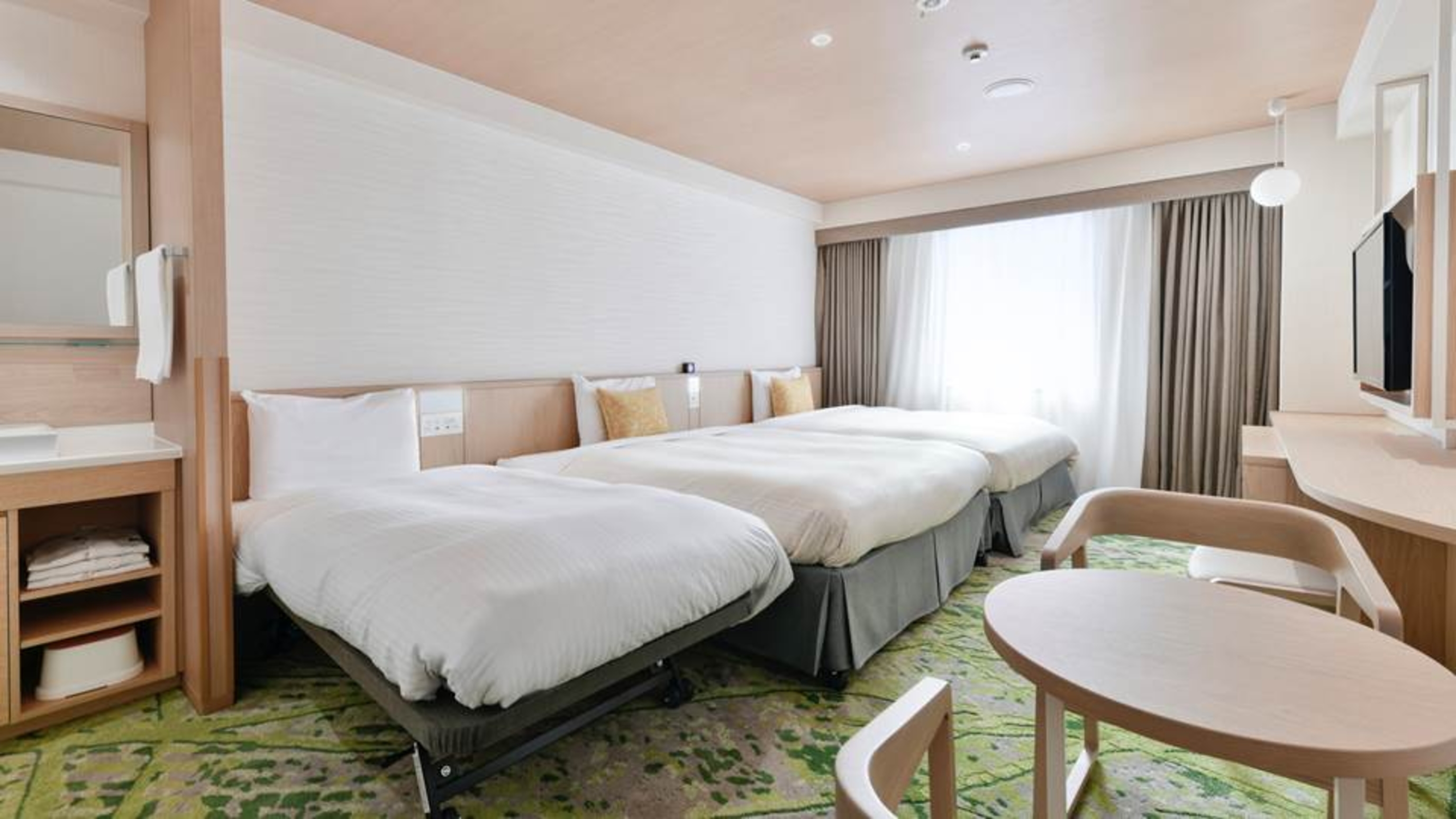 ベッセルホテルのエキストラトリプルルーム。清潔感のある白い壁の部屋にベッド2台とエキストラベッド