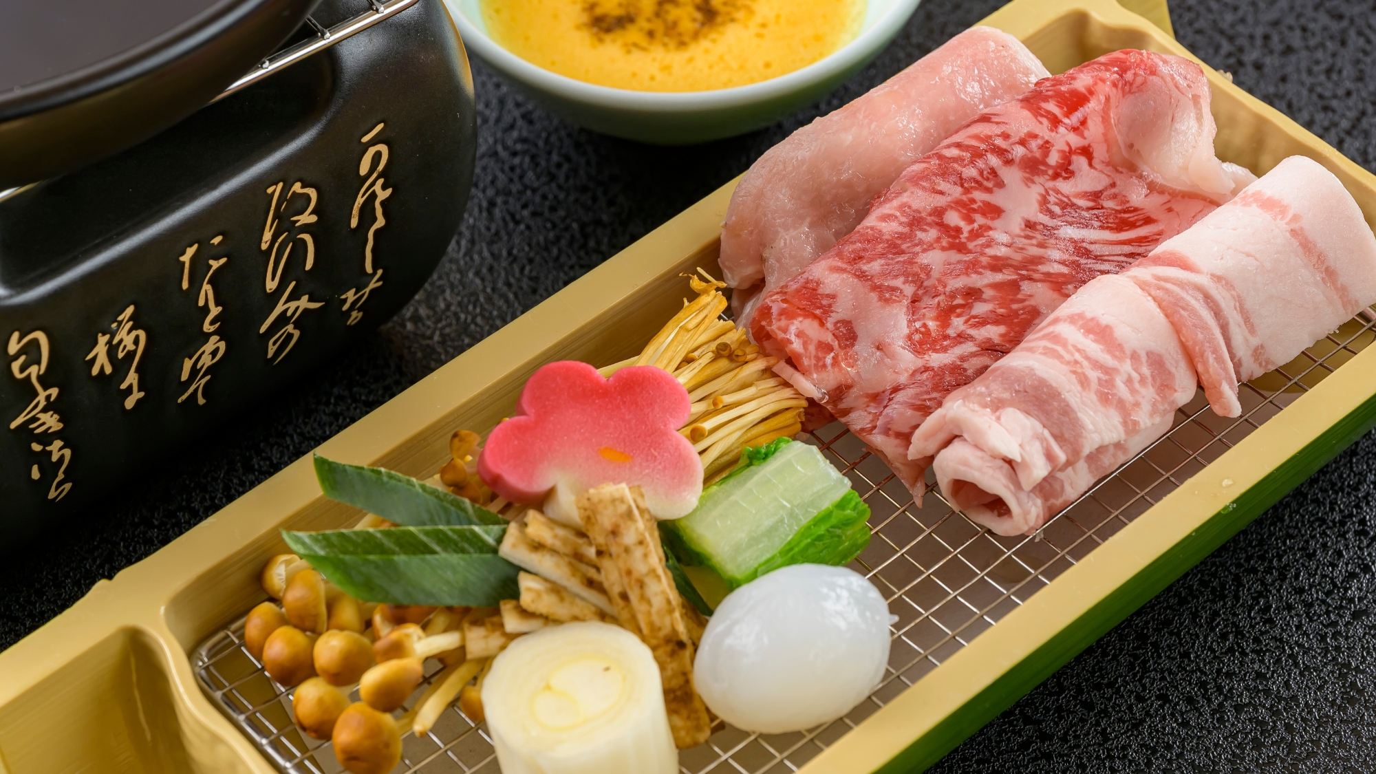 竹筒に盛られた国産牛と豚肉は、相盛り鍋でお召し上がりください。冬の万葉和会席より