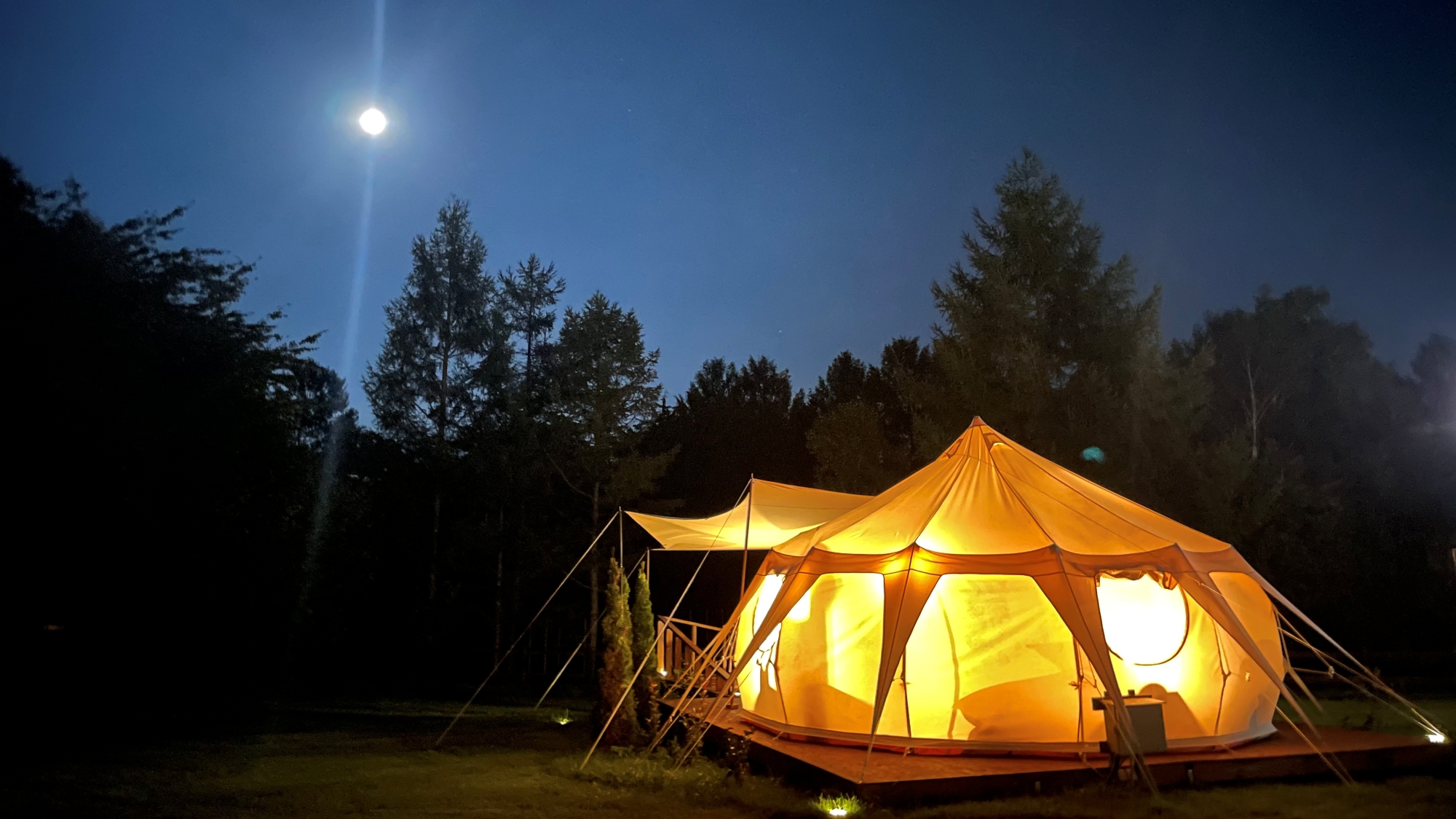 *グランピングテント（夜）／ソーラーライトを灯し、ガーデンテーブルに出て星空観察が楽しめます。