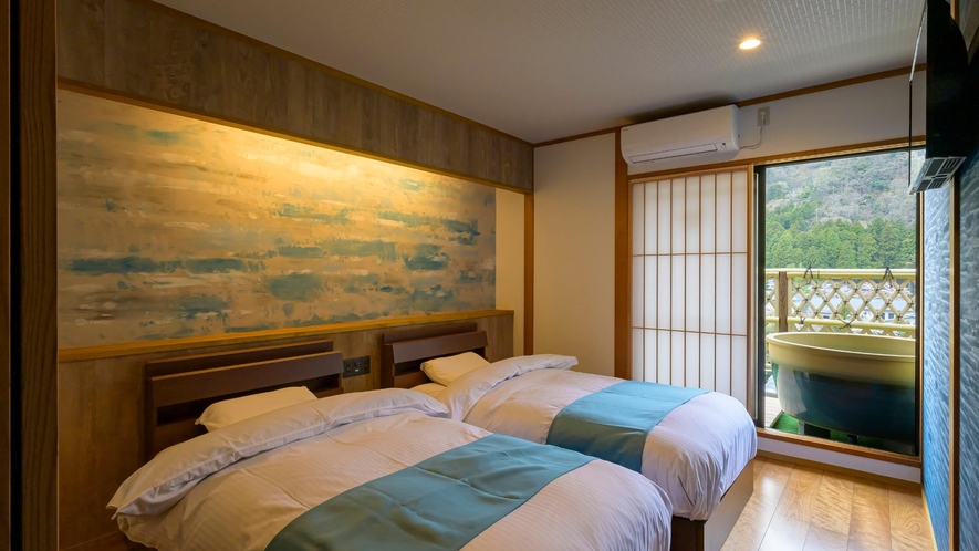 【最上階露天風呂・サウナ付和洋室】空色が涼し気な最上階客室のベッドルーム。