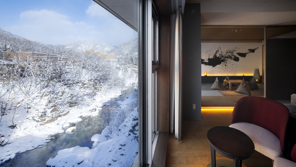 【ファミリールーム】窓に向かって置かれたソファから眺める冬景色