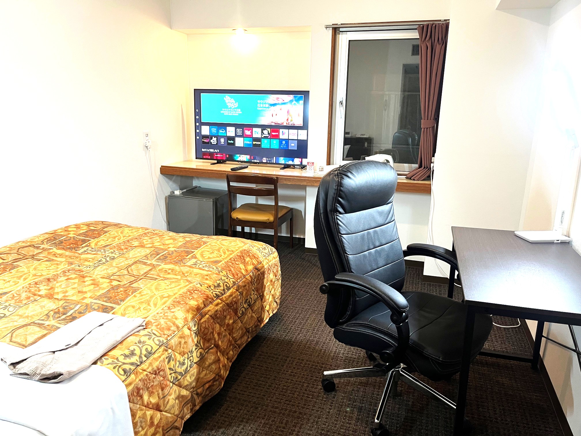 ダブルベッド1台とデスク・チェア・電気スタンドを設置したお部屋です。