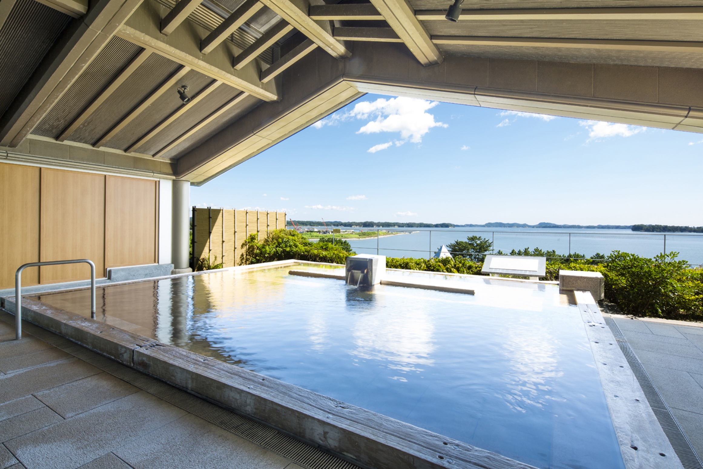 松島一の坊の露天風呂 Scenic Open-Air Baths Panoramic Views: One of the highlights of Matsushima Ichinobo is its open-air baths, particularly those located on the top floor, offering a panoramic view of Matsushima's islands. The "Yaoyashima no Yu" bath allows guests to immerse themselves in the natural hot spring waters while gazing at the horizon, where the 260 islands, known as "Happi Yashima," create a picturesque spectacle. Even on rainy or snowy days, the view remains exceptional, allowing guests to forget the passage of time as they relax in the spa.