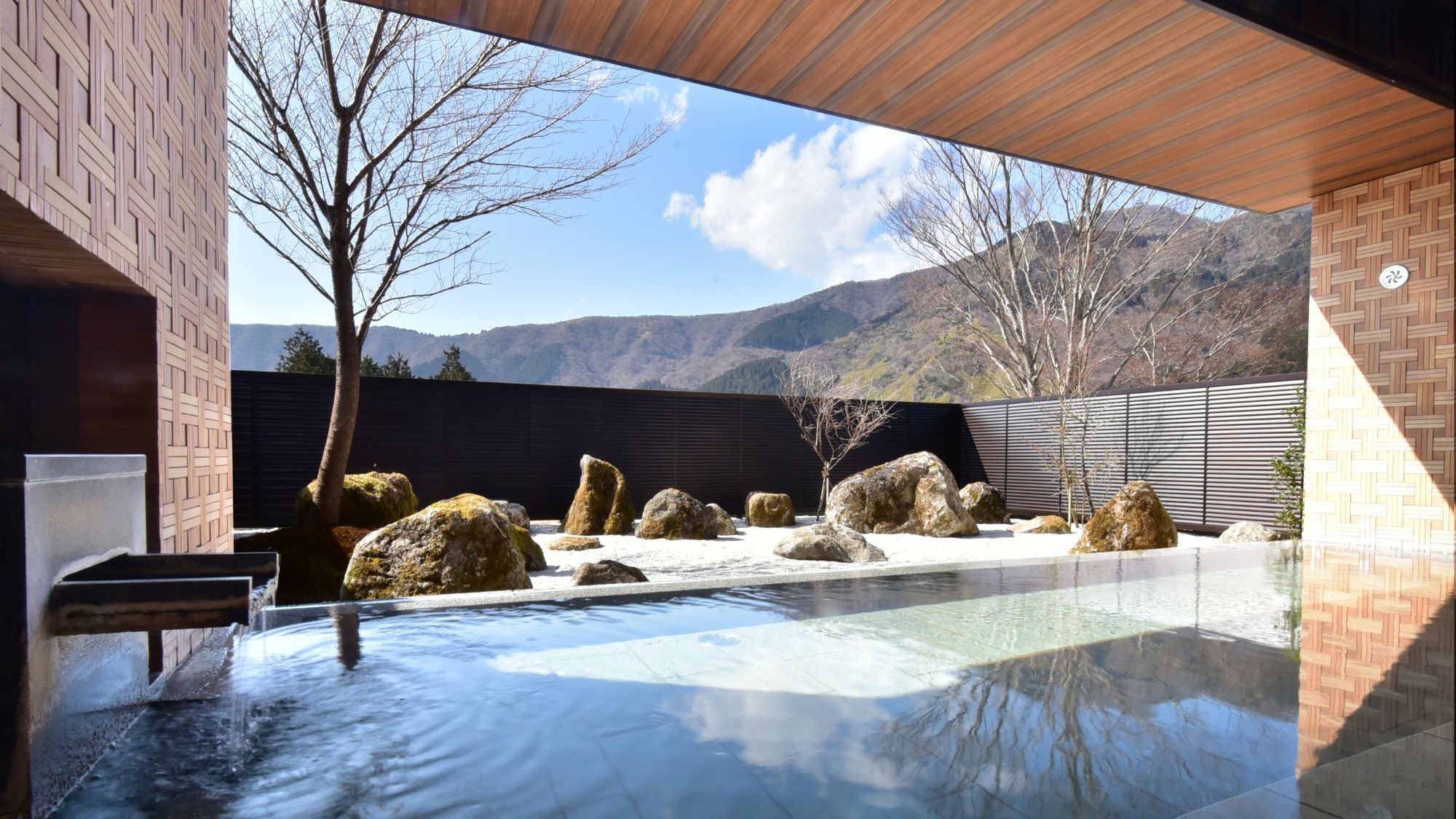 【露天風呂】2025年3月1日庭園を枯山水にリニューアル。箱根寄木細工をモチーフとした壁面が特徴的。