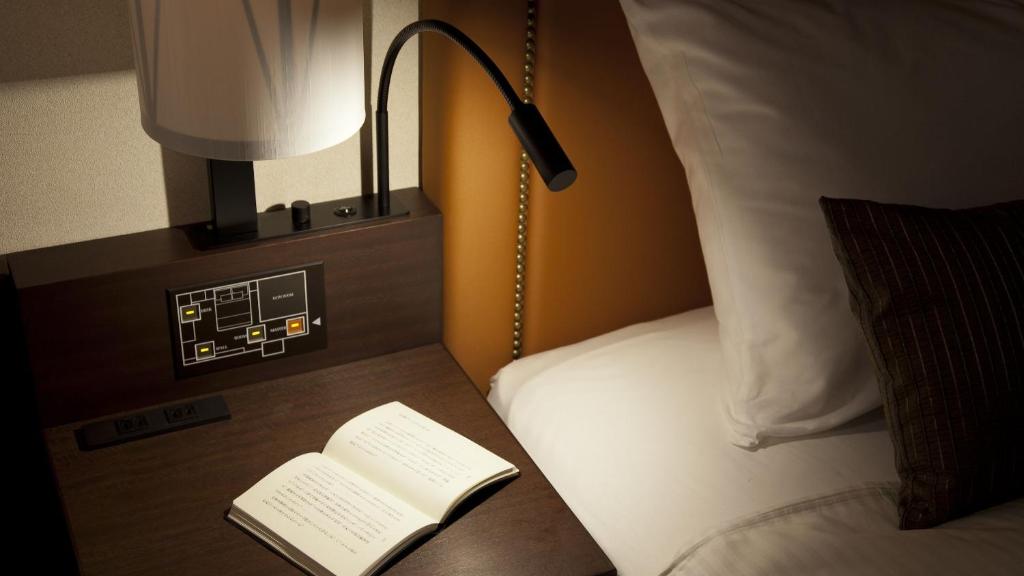 【客室設備】ベッドの側には読書灯が備わっております。