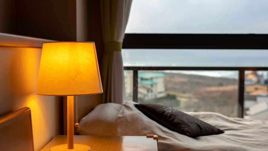 淡く灯るランプと、沈みゆく夕日。佳松苑の客室は全室海が一望できます。