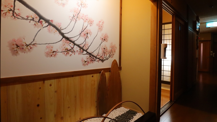 大きな桜の絵画に砂利を敷き詰め、風情がある客室通路となっています。