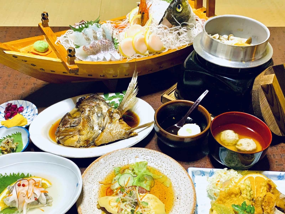 椿荘の夕食。舟盛りの刺身と金目鯛の煮付け、釜飯、小鉢が並ぶ