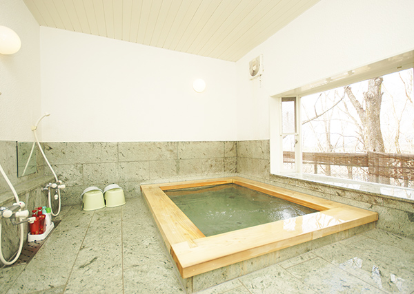 石張りの天然ヒノキが香るお風呂は、大人が5人入れる広さ。野鳥も訪れる窓からの景色が清々しい気分に