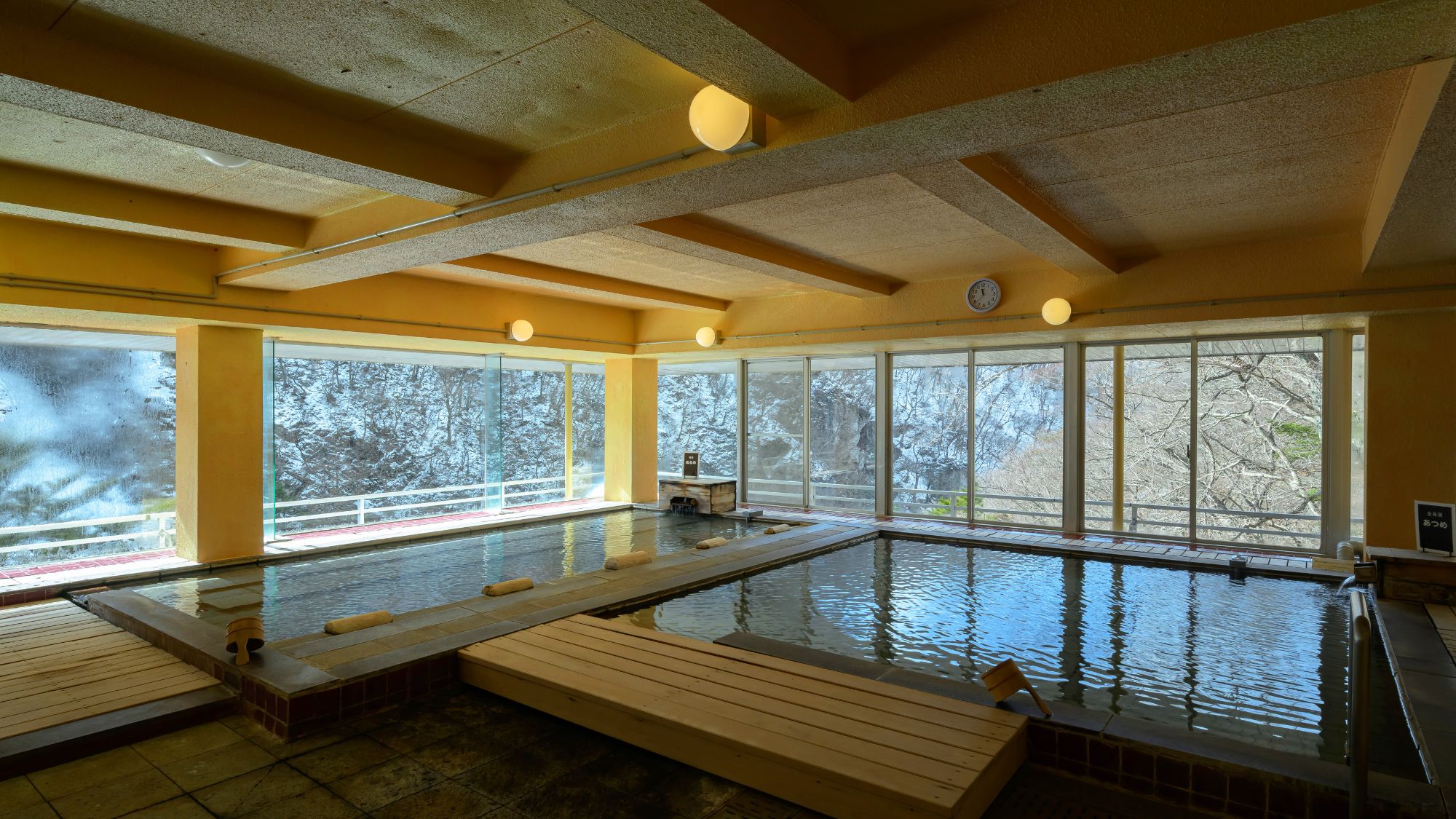 【展望風呂】全面ガラス張りの開放感と源泉掛け流しの天然温泉100％を一日中お楽しみいただけます。