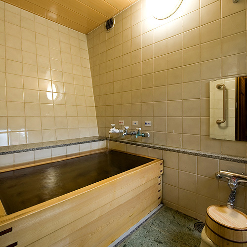 A Japanese-style room with a bath that flows directly from the source