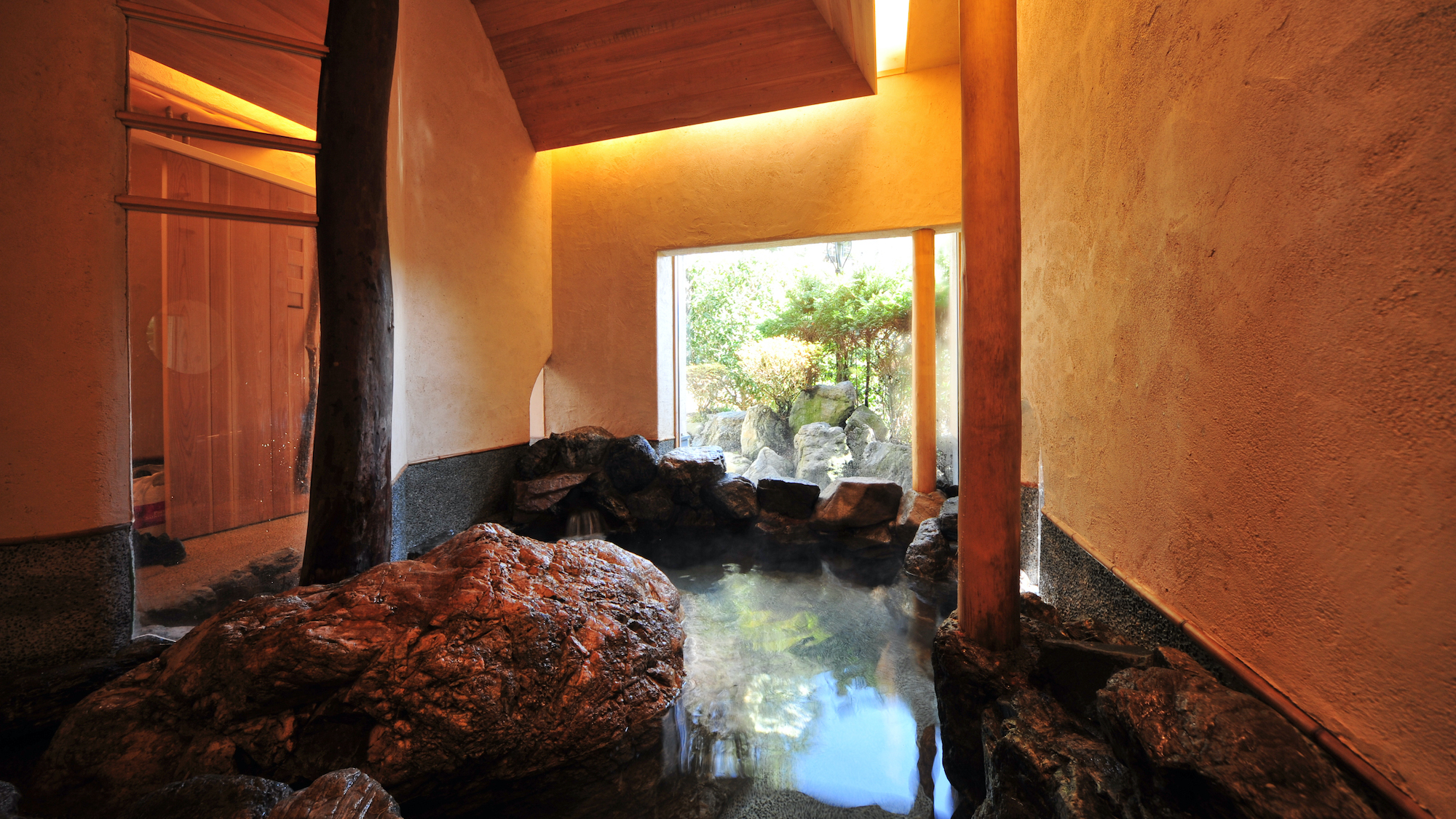 【貸切風呂「岩風呂」】大岩をぐるりと取り囲んだ、独創的な貸切風呂。