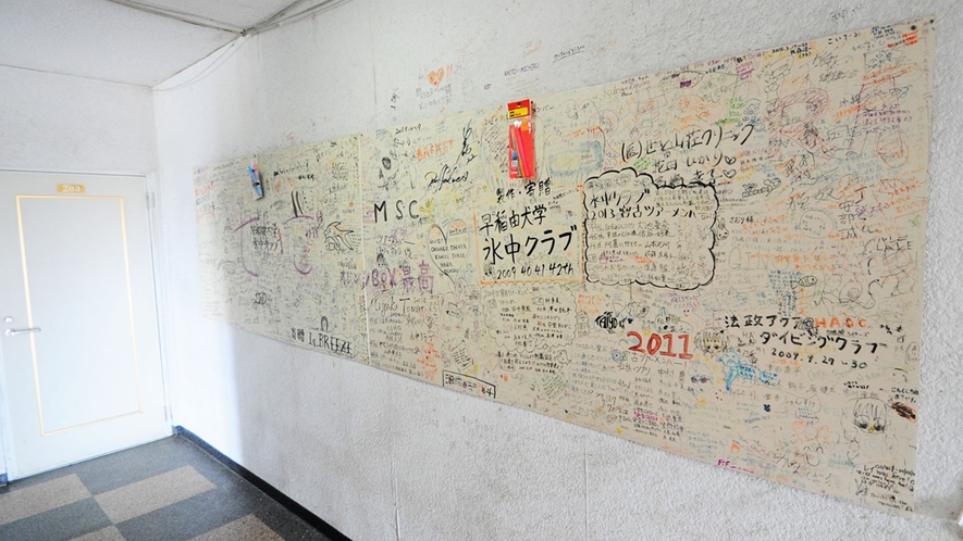 【館内】全国から訪れた学生さんの寄せ書きで一面いっぱいの壁