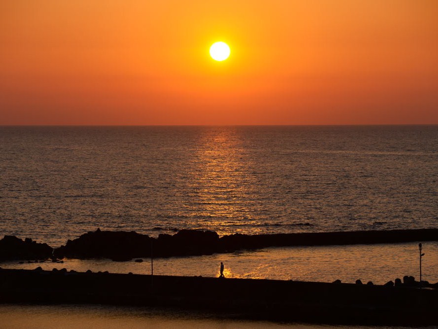 日本海の水平線に沈む夕日　天気がいいと宿・近辺より望めます。