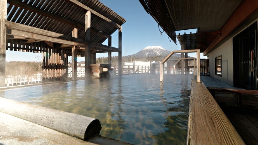 【7階大浴場・石室の湯】金の弓／露天風呂（冬）雄阿寒岳を望むことができます。