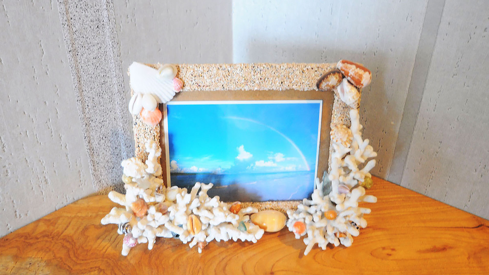 【洋室ツイン】貝殻で縁取られたフォトフレーム。中には綺麗な海の景色が飾られています。