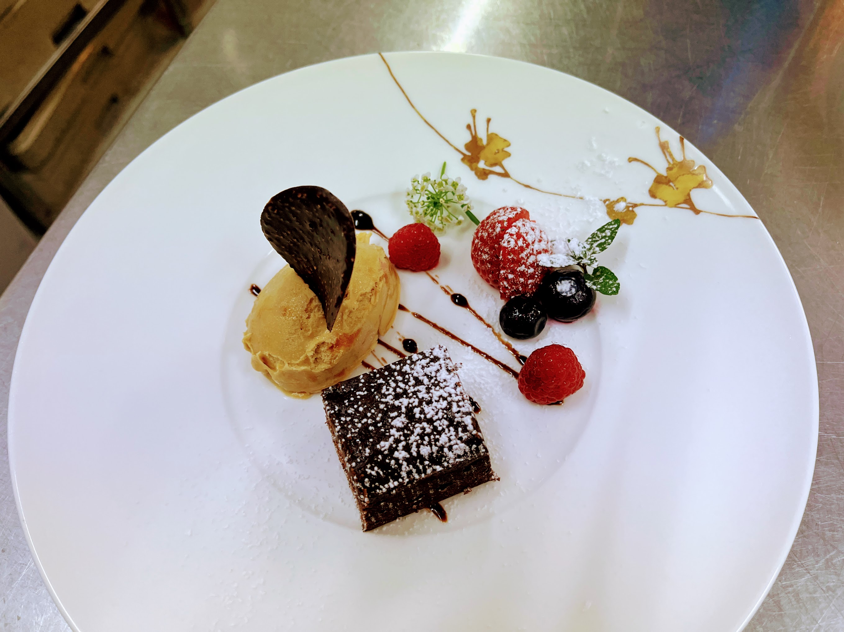 キャラメル味のアイスクリームとブラウニーのケーキ・ベリーを添えて