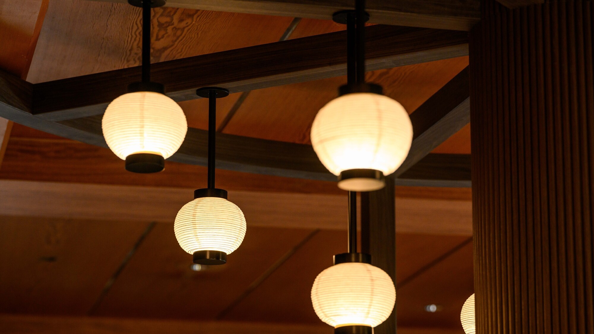 【ロビーラウンジ】提灯型の天井照明が、シックで落ち着いたロビーに優しい光を添えています