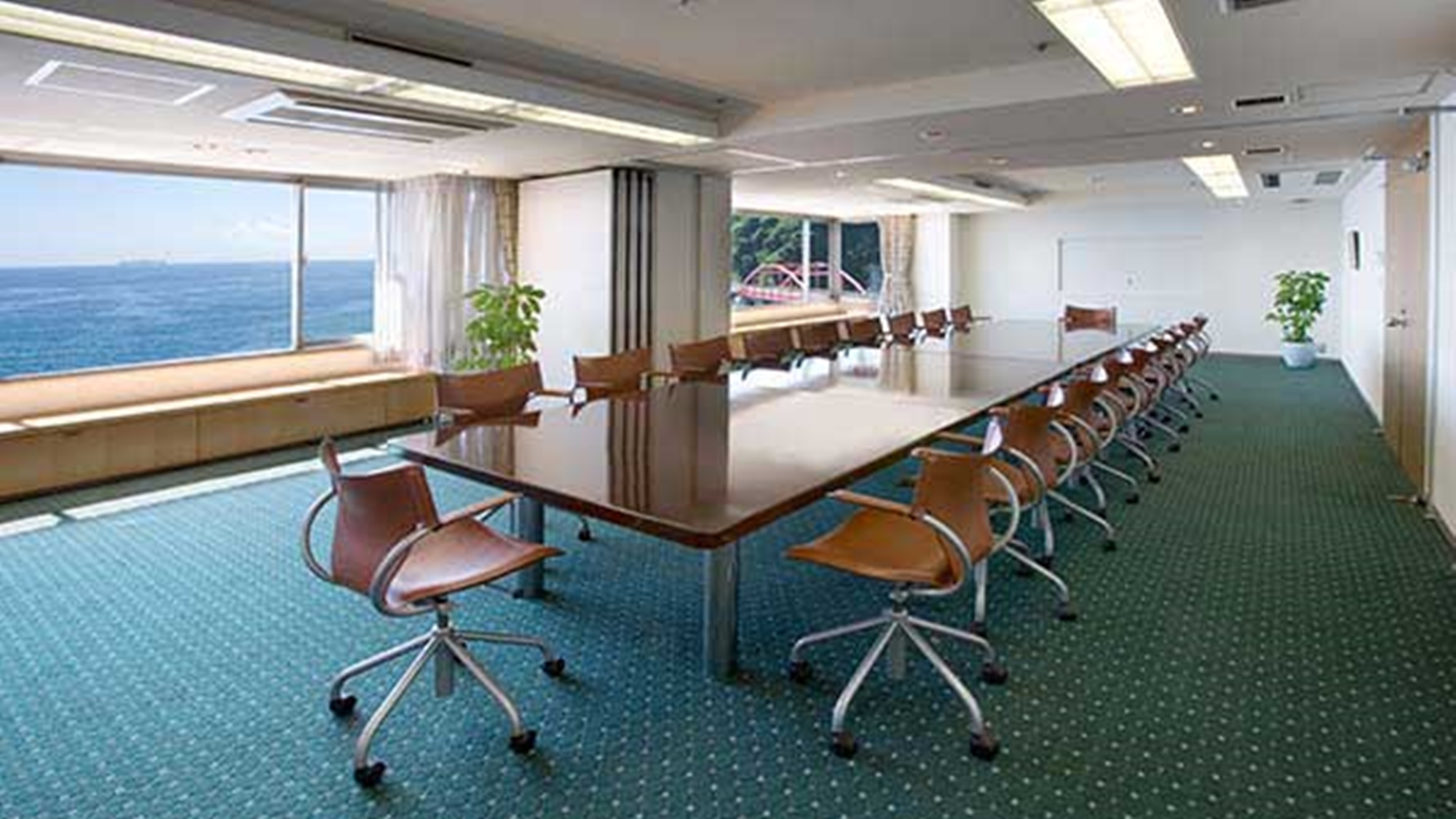 *小会議室（ハイビスカス）／眺望豊かなスペースに、木製1枚板の重厚な テーブルを2本配置。2分割も可