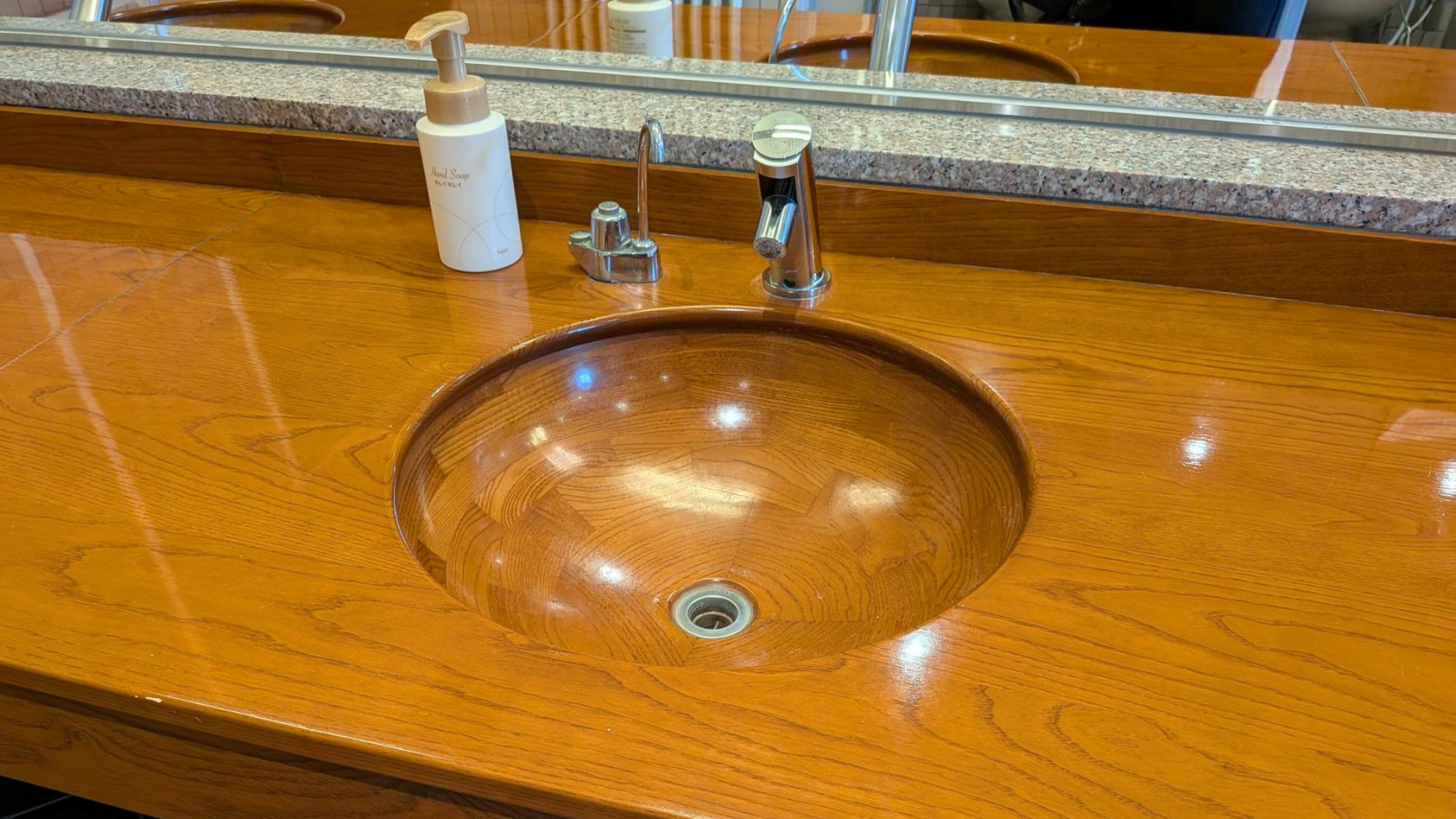 *【共用トイレ／手洗い場】木をくり抜いた特別仕様の手洗い場。館内にある木を使った装飾は当館の自慢です