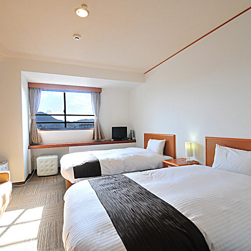 เตียงเดี่ยวในห้องทวินสไตล์ตะวันตกที่ได้รับการอัพเกรดจะมีผ้าห่มนวม