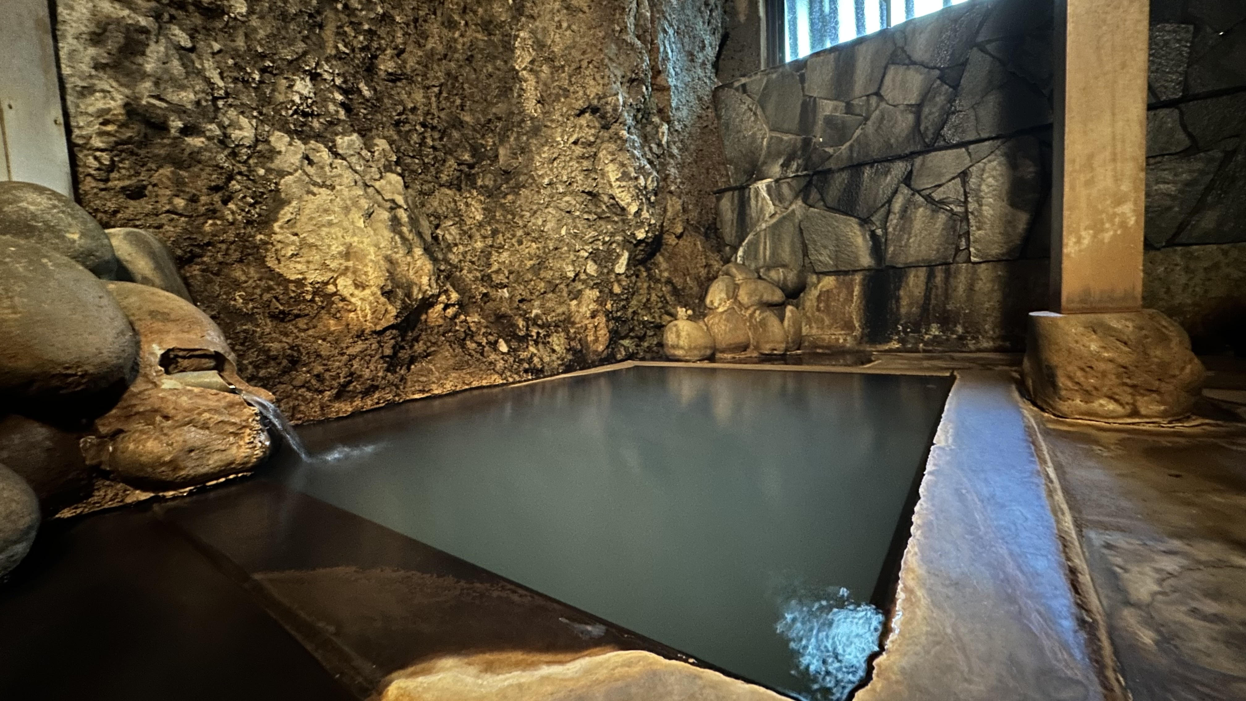 湯舟から温泉が溢れる洞窟風呂