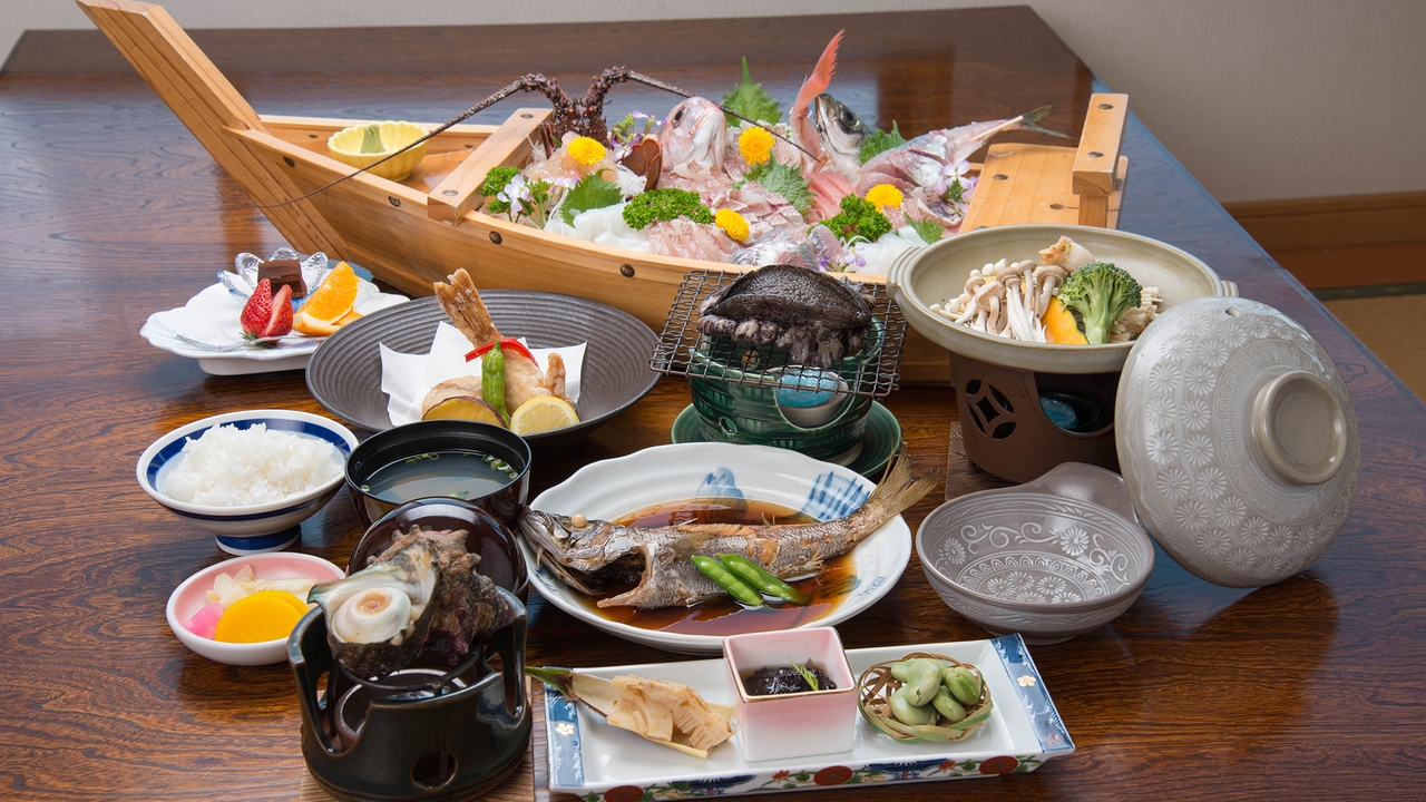 海と夕日の展望風呂の宿おしなやの夕食。舟盛りに小鉢と煮魚が並ぶ